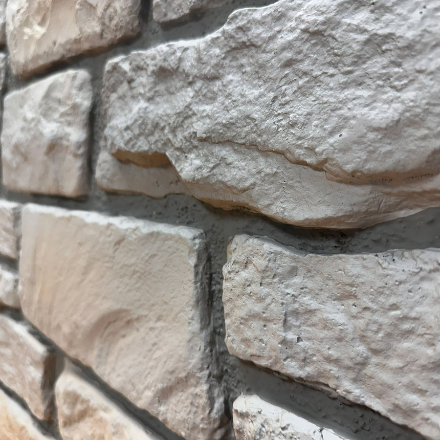 Close-up of Cotswold Stone in Fossil White showing the fossil-grey limestone texture and irregular stone faces